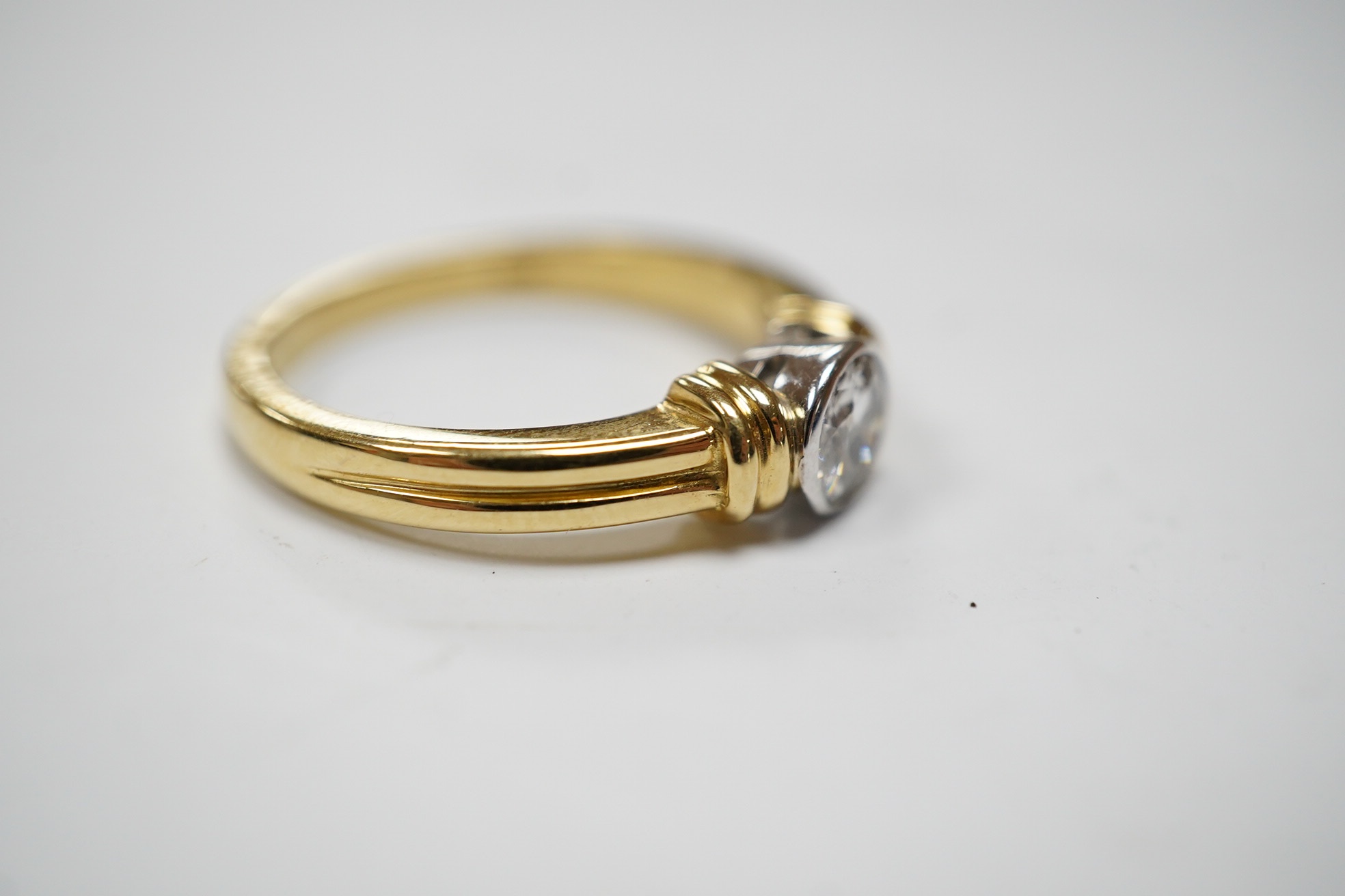 A modern 18ct gold and collet set solitaire diamond ring, size O, gross weight 5.7 grams. Condition - fair to good.